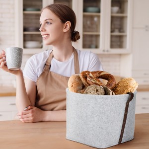 Young beautiful girl housewife in the kitchen in an apron with coffee and croissant enjoys her morning