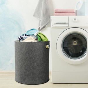 Modern washing machine against blue wall, space for text